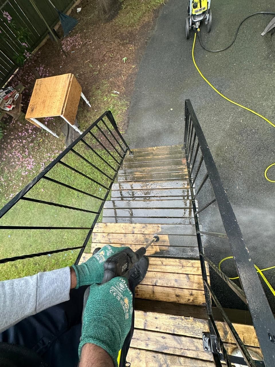 Pressure washing wooden deck stairs, mid-job