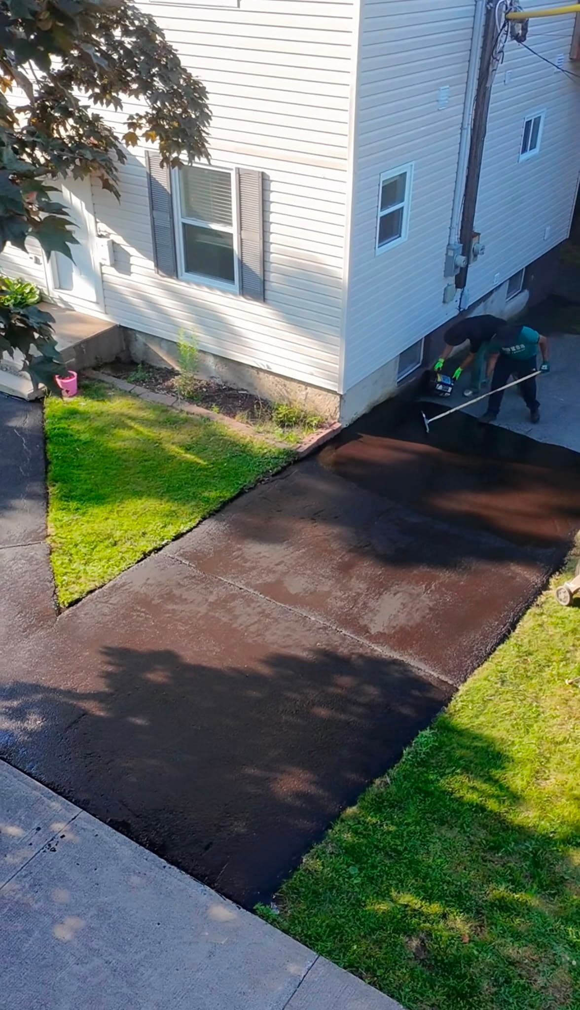 ProMax crew applying fresh sealcoating to a residential driveway